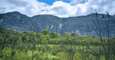 Paisagem natural da Serra do Cipó MG com paredões rochosos, vegetação verde e cachoeiras descendo