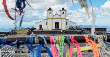 Santuário da Piedade em Caeté, MG, visto ao fundo com fitas coloridas em primeiro plano e céu