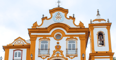 Capela Histórica com cores Amarelas, com uma torre que possui sino em São João del Rei MG
