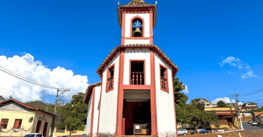 Capela de Nossa Senhora do Ó, com cores azul e branca, com céu azul em Sabará MG