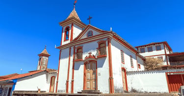 Capela histórica em Diamantina MG com fachada branca e detalhes vermelhos sob céu azul