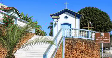 Pequena capela histórica branca e azul sobre muro de pedras. Ouro Branco, Minas Gerais
