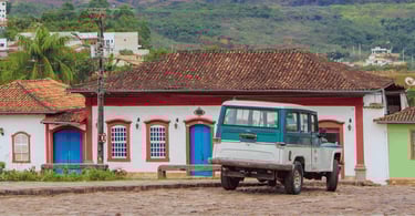 Charme de Catas Altas mostrando uma rua de paralelepípedos, um jipe antigo e uma casa histórica
