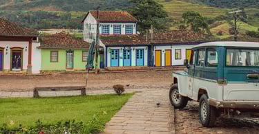 Casario colonial em Catas Altas MG com fachadas coloridas, rua de pedra e veículo antigo