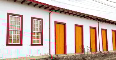 Casa histórica do periodo colonial, com janelas vermelhas e portas amarelas em Cachoeira do Campo