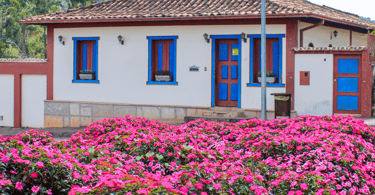 Casa histórica do periodo colonial com um lindissimo jardim com flores rosas a frente, Santa Bárbara