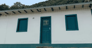 Casa colonial branca com portas e janelas verdes em São Bartolomeu