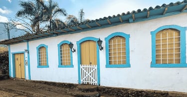 Casarão colonial preservado com janelas azuis e portas amarelas em Morro d’Água Quente MG