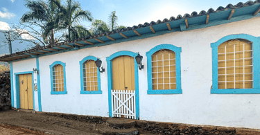 Casa histórica com corez azul, branca e amarela, em Morro D'Água Quente, distrito de Catas Altas MG