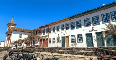 Vista de um largo pavimentado com motos e edifícios coloniais brancos em Diamantina, MG