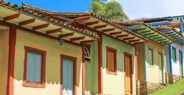 Casas coloridas em Lavras Novas com fachadas simples, portas de madeira e telhados coloniais