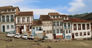 Casario colonial de Ouro Preto com fachadas históricas, sacadas e telhados de barro em rua de pedra