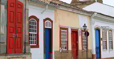 Casinhas tradicionais de São João del Rei com paredes em branco e amarelo e janelas com molduras