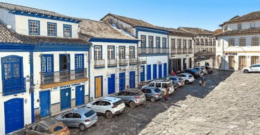 Casarões coloniais brancos com portas e janelas azuis em uma rua histórica de Diamantina