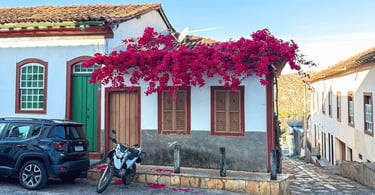 Casario histórico de Diamantina com flores coloridas, porta verde, rua de pedra e clima colonial