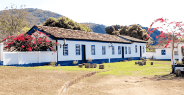 Casas históricas do periodo colonial com cor branca e azul, com árores nativas na Vila do Biribiri