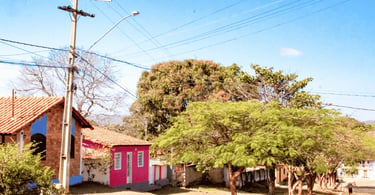 Centrinho de Conselheiro Mata MG, com casas coloridas, árvores, rua tranquila e clima de distrito