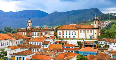 Vista panorâmica de Ouro Preto com igrejas históricas, telhados coloniais e montanhas ao fundo