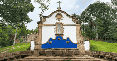 Chafariz de São José, construção histórica de pedra sabão, com cores brancas e azuis, com vegetação
