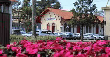 Estação ferroviária de Itabirito MG com fachada histórica, portas vermelhas e flores rosas