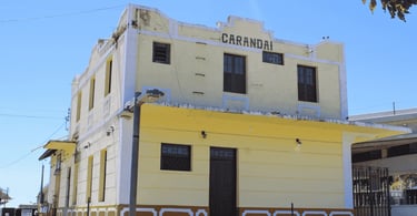 Estação Ferroviária de Carandaí em Minas Gerais com fachada histórica amarela e céu azul