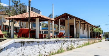 Antiga estação Ferroviária no distrito de Hermilio Alves, com bancos de cor vemelha e ceu azul