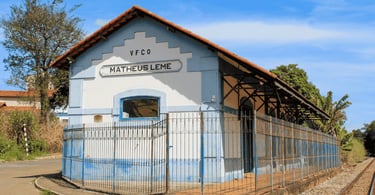 Estação ferroviária histórica de Mateus Leme, em Minas Gerais, com trilhos e fachada preservada