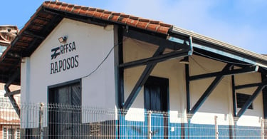 Estação ferroviária de Raposos, Minas Gerais, com fachada branca, detalhes azuis, telhado colonial