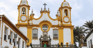 Igreja Matriz de Santo Antônio em Tiradentes com fachada barroca, torres amarelas e cruzeiro históri
