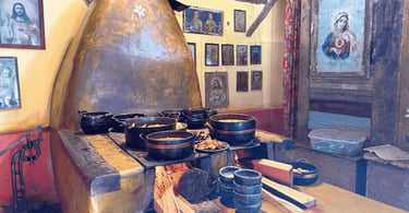 Cozinha tradicional de Itatiaia, em Minas Gerais, com fogão a lenha aceso, panelas de ferro