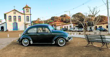 Fusca preto antigo estacionado na praça principal de Extração, Diamantina, em frente à igreja