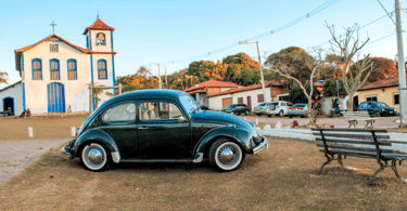 Fusca com uma igreja historica ao fundo, em Curralinho/extração, distrito turistico de Diamantina MG
