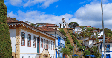Casas, escadaria, árvores e igreja histórica no centro turistico de Serro