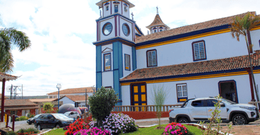 Igreja Matriz de Datas, na praça com flores. Ponto turistico de Minas Gerais