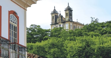 Igreja , vegetação e janela de uma casa do periodo colonial em Ouro Preto, 