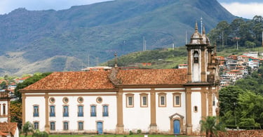 Igreja histórica com telhado colonial e montanhas ao fundo em Ouro Preto, Minas Gerais