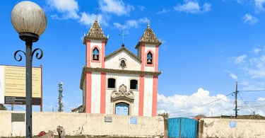 Fachada da igreja matriz branca e rosa de Lavras Novas vista da rua
