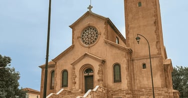 Igreja de cor marrom, com escadaria e vitrair, céu nublado em Miguel Burnier, distrito de Ouro Preto