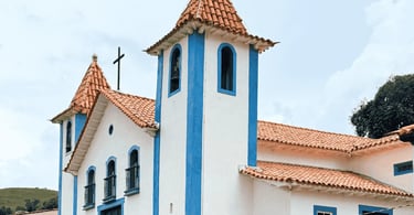 Igreja Matriz de São Bartolomeu, com cor branca e azul, céu nublado, no distrito de Ouro Preto