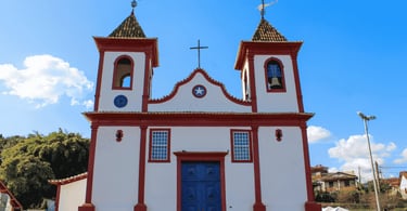 Fachada da Igreja Matriz de Sabará, em Minas Gerais, com paredes brancas, detalhes vermelhos