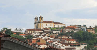Igreja no Alto, casas abaixo e céu nublado em Ouro Preto Minas Gerais