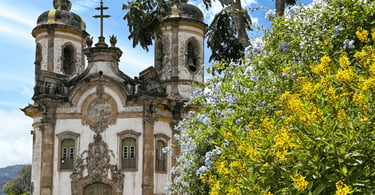 Igreja São Francisco de Assis em Ouro Preto com fachada barroca e jardim florido ao redor