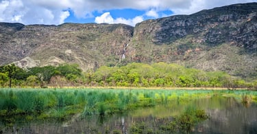 Montanhas, vegetação e uma cachoeira na Serra do Cipó, em Minas Gerais