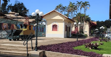 Antiga estação em Itabirito com jardineiras, poste colonial e pequeno trem em exposição