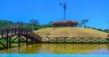 Moinho em uma ilha, com água em volta e uma ponte, no Parque Ipanema em Ipatinga