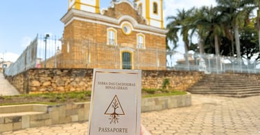 Passaporte da Serra das Cachoeiras diante da Igreja Matriz de Carrancas, Minas Gerais