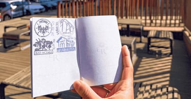 Passaporte da Estrada Real aberto exibindo carimbos de Itabirito e outras cidades sob o sol