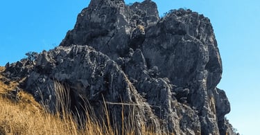 Pedra Grande em Igarapé com formação rochosa imponente, céu azul e vegetação seca ao redor