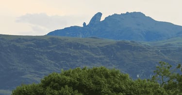 Pico do Itacolomi em Ouro Preto MG visto entre montanhas, vegetação verde e céu claro