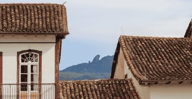 Telhados coloniais de Ouro Preto, MG, com o Pico do Itacolomi ao fundo entre casarões históricos